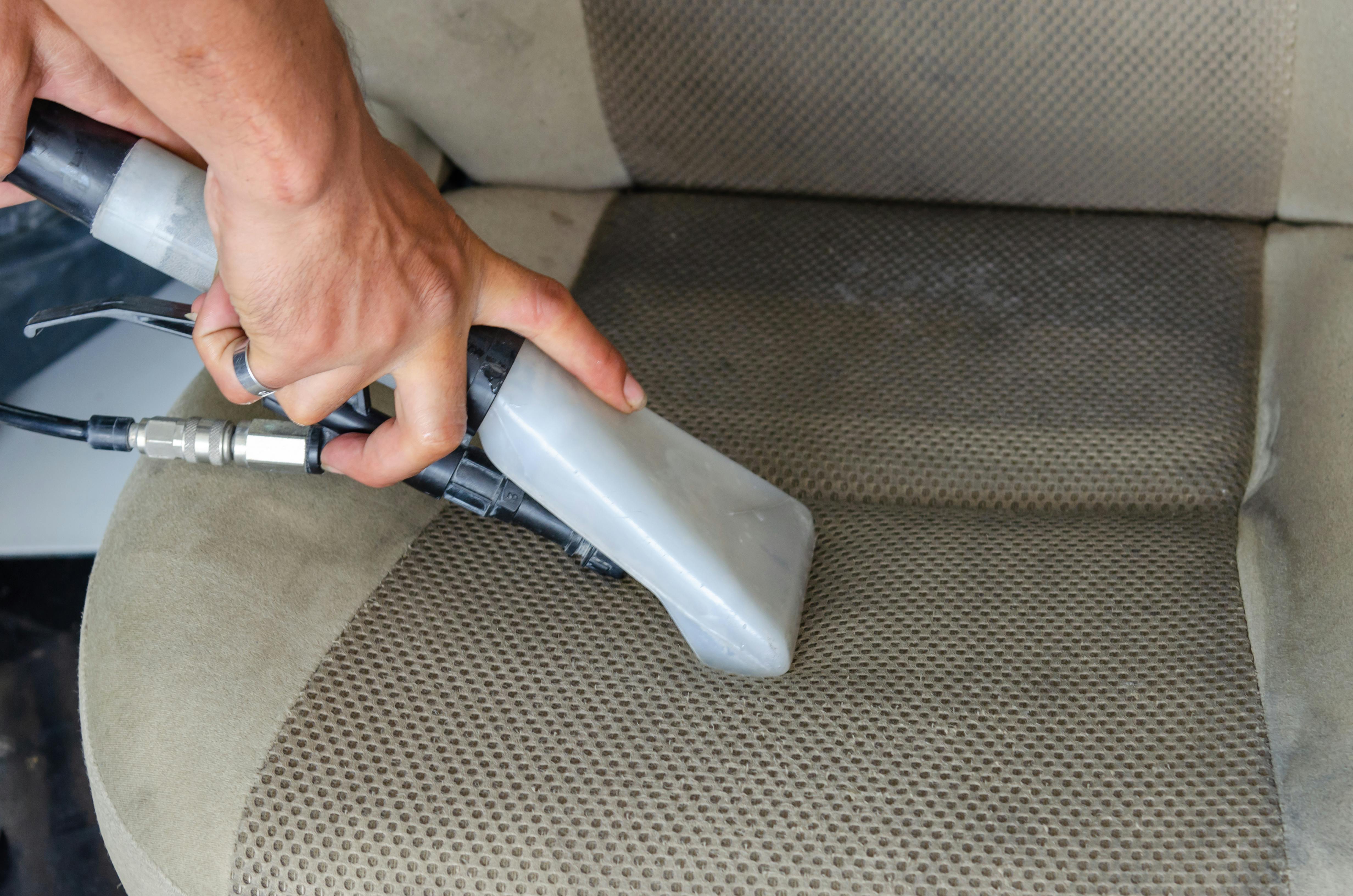 dreckiger Autosessel wird gestaubsaugt
